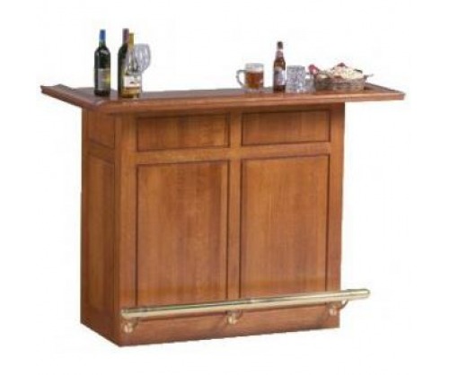 Blonde wood dry bar with alcohol bottles on the counter with a brass foot rest