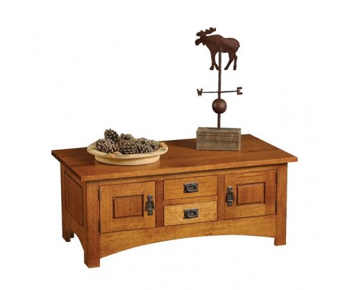 Wooden coffee table with a light colored stain with doors on right and left with two drawers in the middle. Bowl of pinecones and a moose weather vane