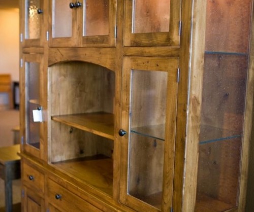 Six door china cabinet in lighter stain with nothing in it sitting on the showroom floor