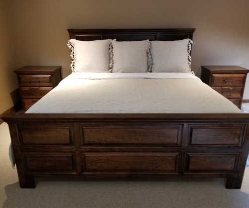 Wooden panel bed with a mattress and pillows