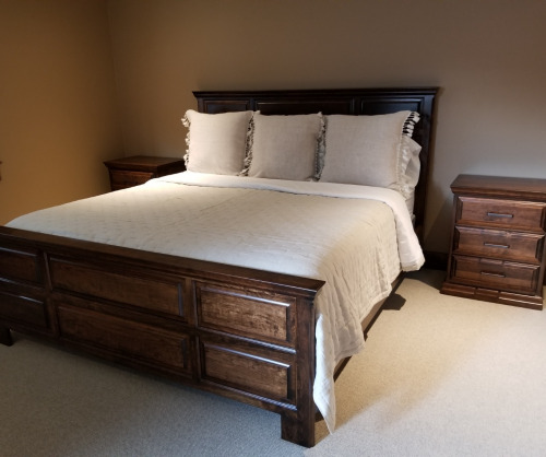 Wooden panel bed with a mattress and pillows with two nightstands