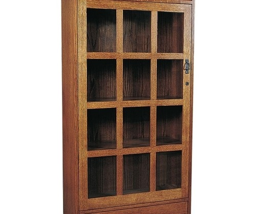 Blonde wooden display case with 16 nooks filled with books, decorations, pictures and other items behind a glass door with black hardware